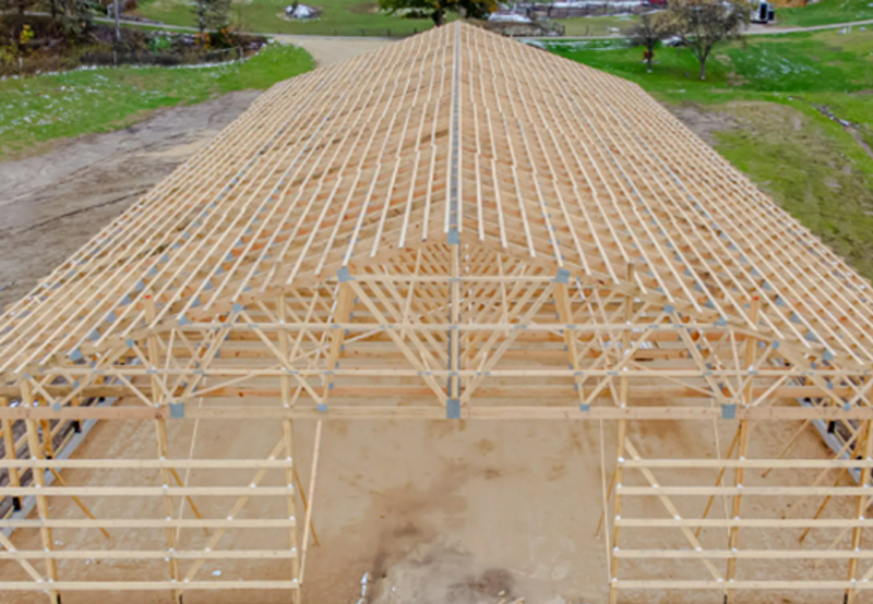 Post frame building roof trusses under construction